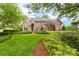 Stunning two-story brick home featuring a meticulously landscaped front yard with lush green grass and manicured bushes at 18920 Peninsula Club Dr, Cornelius, NC 28031