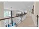 Spacious hallway on upper level with railing overlooking lower level, with plenty of light and neutral decor at 18920 Peninsula Club Dr, Cornelius, NC 28031