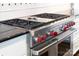 This kitchen showcases a stainless steel Wolf gas cooktop, red knobs, and black granite countertops at 18920 Peninsula Club Dr, Cornelius, NC 28031