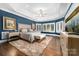 Stunning main bedroom with tray ceilings, bay windows, a sitting area, and a plush rug over hardwood flooring at 18920 Peninsula Club Dr, Cornelius, NC 28031