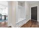 This mudroom showcases a custom white cubby bench with storage, adjacent to a doorway and dark wood floor at 18920 Peninsula Club Dr, Cornelius, NC 28031