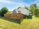 Sunny backyard showing a well-maintained lawn, trees, and wood fencing at 2017 Beckwith Ln, Waxhaw, NC 28173