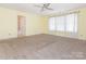 Bright, carpeted bedroom features ensuite bathroom access, window, and ceiling fan at 2017 Beckwith Ln, Waxhaw, NC 28173