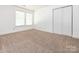 Neutral bedroom featuring soft carpet flooring, a large window, and a spacious closet at 2017 Beckwith Ln, Waxhaw, NC 28173