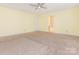 Bright, carpeted bedroom with an ensuite bathroom featuring a ceiling fan and large window at 2017 Beckwith Ln, Waxhaw, NC 28173