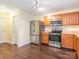A well-equipped kitchen with stainless steel appliances, wooden cabinets and wood floors at 2017 Beckwith Ln, Waxhaw, NC 28173