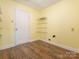 Functional laundry room featuring wood-look floors and convenient wire shelving at 2017 Beckwith Ln, Waxhaw, NC 28173