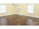 Living room showcasing hardwood floors, yellow walls, two large windows, and a front door at 2017 Beckwith Ln, Waxhaw, NC 28173