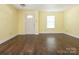 Bright living room showcasing hardwood floors, yellow walls, a front door, and a window at 2017 Beckwith Ln, Waxhaw, NC 28173