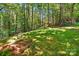 Expansive backyard with a horseshoe pit, ideal for outdoor games surrounded by lush greenery and mature trees at 221 Grayrock Dr, Statesville, NC 28677
