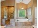 Luxurious bathroom with a glass-enclosed shower and relaxing jacuzzi tub by a sunny window at 221 Grayrock Dr, Statesville, NC 28677