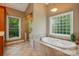 Bathroom with a jacuzzi soaking tub, tiled surround, large sunny window and separate shower at 221 Grayrock Dr, Statesville, NC 28677