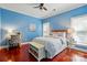 Bedroom with hardwood floors, neutral bedding, desk, stylish chair and bright blue walls at 221 Grayrock Dr, Statesville, NC 28677