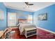 Bedroom with hardwood floors, neutral bedding, stylish decor, and bright blue walls at 221 Grayrock Dr, Statesville, NC 28677