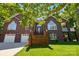 Stunning brick home featuring a manicured lawn, two-car garage, and welcoming entrance with beautiful landscaping at 221 Grayrock Dr, Statesville, NC 28677