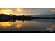 Golden hour lake scene with reflections on a glassy surface, framed by trees at 221 Grayrock Dr, Statesville, NC 28677