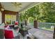 Well-lit covered porch with comfortable wicker furniture and views of the lush surroundings at 221 Grayrock Dr, Statesville, NC 28677