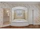 Bright bathroom featuring a large soaking tub, shower, and designer wallpaper at 2322 Hopedale Ave, Charlotte, NC 28207