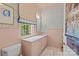 Stylish bathroom with pink walls, patterned wallpaper, and a large window to brighten the space at 2322 Hopedale Ave, Charlotte, NC 28207