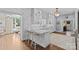 Open kitchen features marble countertops, white cabinets, bar seating, and modern lighting at 2322 Hopedale Ave, Charlotte, NC 28207