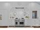 Gourmet kitchen features stainless steel Wolf range and hood with custom white cabinetry at 2322 Hopedale Ave, Charlotte, NC 28207