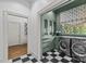 Well-lit laundry room featuring sleek appliances, green cabinetry, and black and white checkered floors at 2322 Hopedale Ave, Charlotte, NC 28207