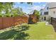 Spacious backyard with artificial grass, playset, climbing dome, and wood privacy fence at 2509 Bay St, Charlotte, NC 28205