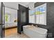 Modern bathroom featuring a standalone tub, stylish black tiling, and view into the bedroom at 2509 Bay St, Charlotte, NC 28205