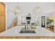 Open-concept kitchen with quartz countertops, an island, a sink, geometric lighting, and views of the living area and staircase at 2509 Bay St, Charlotte, NC 28205