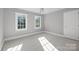 A well-lit bedroom features neutral paint, carpet, and trim, plus bright, double-hung windows and a ceiling fan at 2608 Carmarthen Ct, Matthews, NC 28104