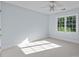This bedroom features a ceiling fan, large window, neutral paint, and carpet at 2608 Carmarthen Ct, Matthews, NC 28104
