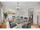 Elegant dining room featuring a glass table, stylish chairs, chandelier, and wainscoting at 2608 Carmarthen Ct, Matthews, NC 28104