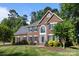 Elegant two-story brick home with a well-manicured lawn, dark shutters, and professionally landscaped garden at 2608 Carmarthen Ct, Matthews, NC 28104