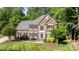 Stately two-story brick home with a manicured lawn, lush trees, and professionally landscaped front yard at 2608 Carmarthen Ct, Matthews, NC 28104
