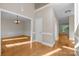 Spacious foyer with hardwood floors, an open staircase, and elegant trim and chandelier at 2608 Carmarthen Ct, Matthews, NC 28104