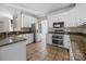 A spacious kitchen featuring granite counters, white cabinets, and stainless steel appliances at 2608 Carmarthen Ct, Matthews, NC 28104