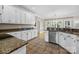 Well-lit kitchen with granite counters, stainless steel appliances, and white cabinets offers a functional design at 2608 Carmarthen Ct, Matthews, NC 28104