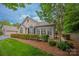 Charming exterior view of home with stone accents, manicured lawn, and lush landscaping at 2704 Polo Club Blvd, Matthews, NC 28105