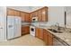Well-lit kitchen with wooden cabinets, white appliances, and granite countertops at 2704 Polo Club Blvd, Matthews, NC 28105