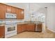An open-concept kitchen boasts wood cabinets, stainless dishwasher, and granite countertops at 2704 Polo Club Blvd, Matthews, NC 28105