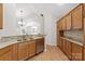 An open-concept kitchen boasts wood cabinets, stainless dishwasher, and granite countertops at 2704 Polo Club Blvd, Matthews, NC 28105