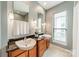 Bright bathroom with dual vessel sinks, granite countertop, and modern fixtures with a window that lets in natural light at 2988 Textile Way, Charlotte, NC 28205