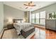 Bright bedroom featuring a plush bed, bench, and hardwood floors, illuminated by natural light from a large window at 2988 Textile Way, Charlotte, NC 28205