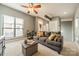 Comfortable living room featuring a plush gray sofa, ceiling fan, and work space at 2988 Textile Way, Charlotte, NC 28205