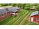 Aerial view of a brick home and its spacious backyard, featuring striped-cut grass and a detached outbuilding at 326 N Greenbriar Rd, Statesville, NC 28625