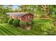 View of brick home and striped-cut backyard, with fencing and mature landscaping at 326 N Greenbriar Rd, Statesville, NC 28625