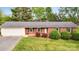 Charming brick ranch home featuring an attached garage, well-manicured lawn, and mature landscaping at 326 N Greenbriar Rd, Statesville, NC 28625
