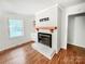 Bright living room featuring a brick fireplace, mantle, and hardwood floors at 326 N Greenbriar Rd, Statesville, NC 28625