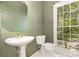 Powder room features a pedestal sink, octagonal mirror, and a large window with lush views at 3710 Cheleys Ridge Ln, Charlotte, NC 28270