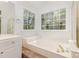 Bright bathroom featuring a soaking tub with jets, a large window, and natural lighting at 3710 Cheleys Ridge Ln, Charlotte, NC 28270